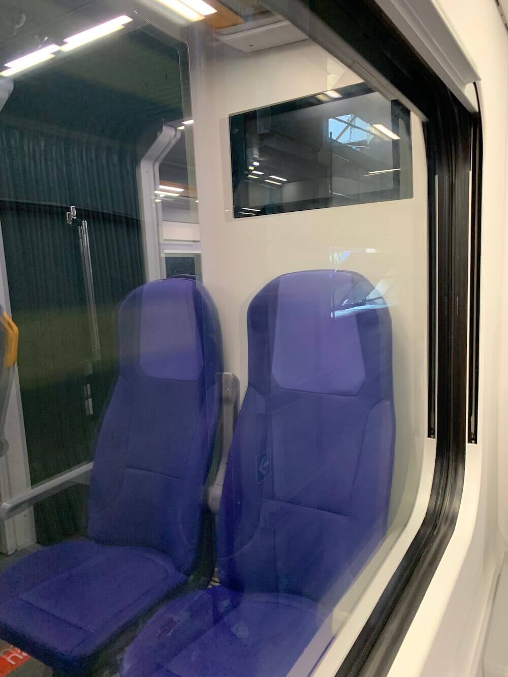 vetro-treno-interno-rigenerato-con-sedili-blu